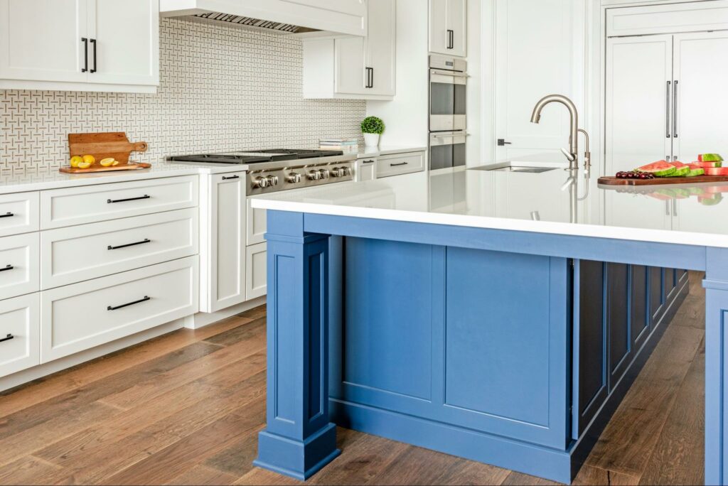 statement blue kitchen island in an all white kitchen- a gorgeous color palette designed by Trade Mark Interiors.